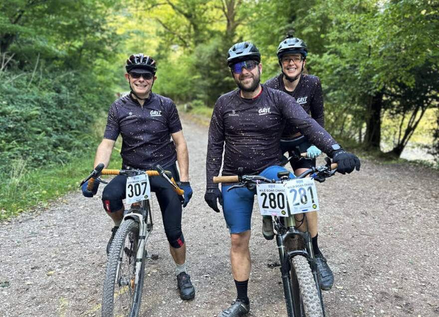 Three riders in matching team kit on a forest track during the Wild Boar Chase